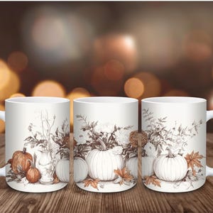 May include: Three white ceramic mugs with a fall theme. Each mug features a sepia-toned illustration of pumpkins, flowers, and leaves. The mugs are set against a blurred background of warm, autumnal colors.