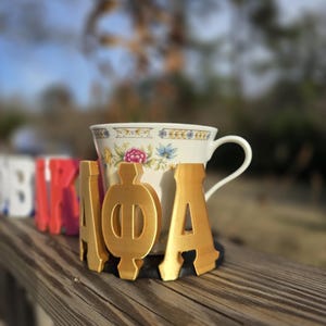 May include: A set of three ceramic mugs with a speckled, matte finish. The mugs are in shades of cream, light gray, and dark gray. Each mug has a simple, minimalist design, perfect for coffee or tea.