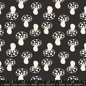 May include: Black fabric with a repeating pattern of white mushrooms. The mushrooms have dotted caps and rounded stems. The fabric has a ruler printed along the bottom edge with the text "RUBY STAR SOCIETY".