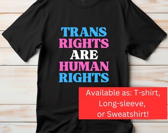 May include: Black t-shirt with the text "TRANS RIGHTS ARE HUMAN RIGHTS" in blue and pink lettering. Available as a t-shirt, long-sleeved top, or sweatshirt.