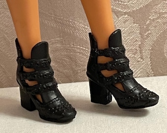 May include: A pair of black heeled ankle boots with cutouts and decorative studs.