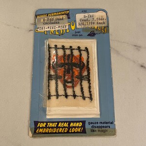 May include: A close-up of an iron-on patch featuring an orange and black embroidered tiger face behind bars. The patch is packaged on a blue and white card with the text "BONDS PERMANENTLY", "B-280 Deal includes #281-#282-#283", "#282", "B-282 Cost. 7.20dz. S/R.1/19 Each", "just iron on...", "FOR THAT REAL HAND EMBROIDERED LOOK!" and "gauze material disappears like magic..."
