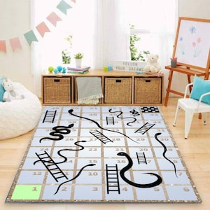 以下が含まれることがあります： 黒色のヘビとハシゴが描かれた白と金のヘビとハシゴのゲームラグ。ラグには1から51までの数字が印刷されています。ラグはキラキラとした仕上げになっています。