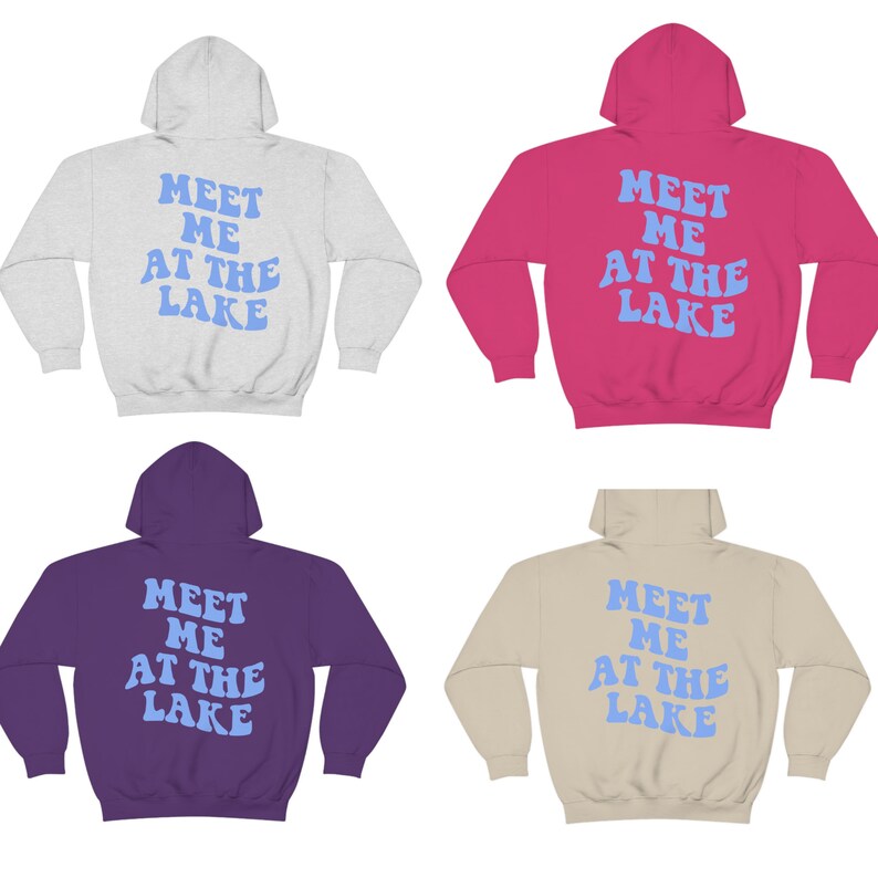 May include: Four hooded sweatshirts in different colors: grey, pink, purple, and beige. Each sweatshirt has the text "MEET ME AT THE LAKE" printed on the back in a light blue retro font.
