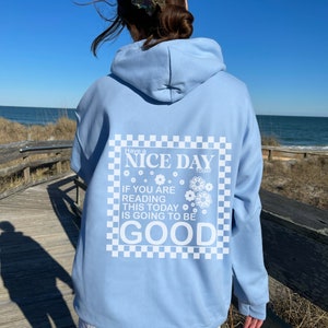 May include: Light blue hoodie with a white graphic print that says "Have a NICE DAY TODAY IF YOU ARE READING THIS TODAY IS GOING TO BE GOOD" with a checkered border and small flower designs.
