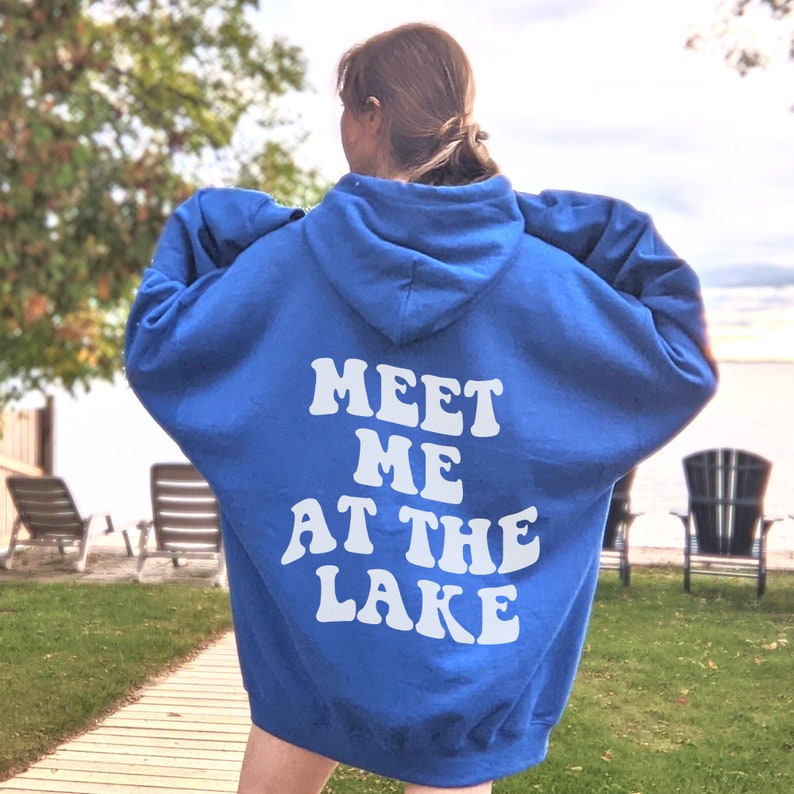 May include: A royal blue hooded sweatshirt with the text "Meet Me At The Lake" in white retro-style lettering on the back.