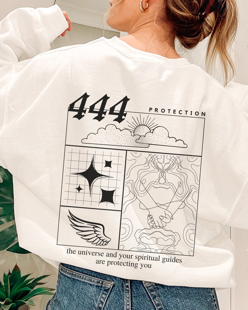 May include: White sweatshirt with a black graphic design featuring the number 444, clouds, a sun, stars, a wing, and hands. The text "PROTECTION" and "the universe and your spiritual guides are protecting you" is also included in the design.