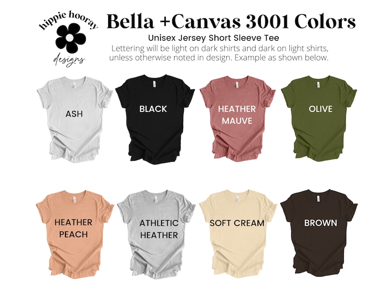 K&ouml;nnte beinhalten: Eine Auswahl an Bella + Canvas 3001 T-Shirts mit kurzen &Auml;rmeln in verschiedenen Farben, darunter Asche, Schwarz, Heidekraut-Mauve, Oliv, Heidekraut-Pfirsich, Athletik-Heidekraut, Weichcreme und Braun. Der Text "Lettering will be light on dark shirts and dark on light shirts, unless otherwise noted in design. Example as shown below." wird &uuml;ber den Shirts angezeigt.