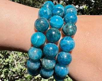 May include: A blue gemstone bracelet with multiple strands of round beads. The beads are a deep blue with a slight shimmer.