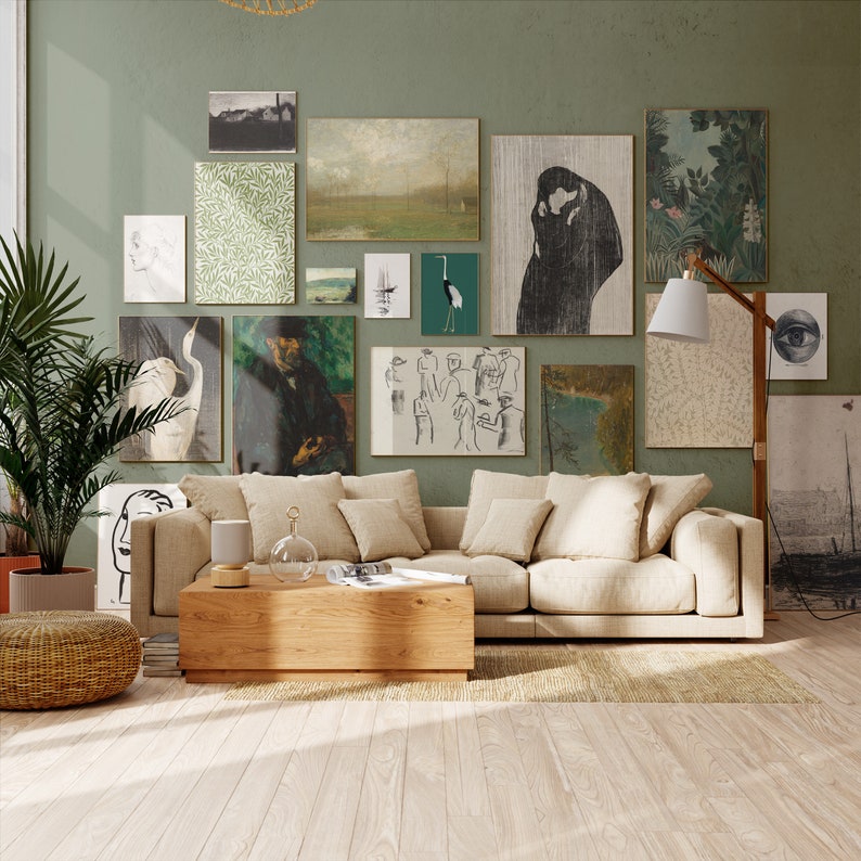 Puede incluir: Un sof&aacute; seccional beige claro con m&uacute;ltiples almohadas en un ambiente de sala de estar. El sof&aacute; est&aacute; frente a una pared con una pared de galer&iacute;a de obras de arte enmarcadas, que incluyen un dibujo en blanco y negro de una pareja bes&aacute;ndose, una pintura de paisaje y una impresi&oacute;n bot&aacute;nica. Una mesa de caf&eacute; de madera se encuentra frente al sof&aacute;.