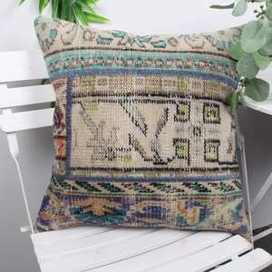 Peut inclure: Un coussin décoratif avec un design vintage tissé à la main. Le coussin présente un patchwork de différents tissus dans des tons de bleu, vert et beige, avec des motifs complexes et des formes géométriques. Le coussin est parfait pour ajouter une touche de style bohème à n'importe quelle pièce.