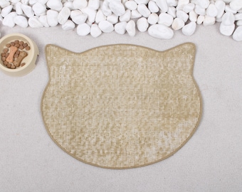 May include: A beige cat-shaped pet food mat with a textured surface.