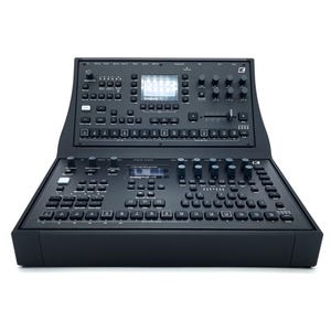 May include: A black analogue synthesizer with a digital display and a variety of knobs, buttons, and sliders. The synthesizer has a built-in sequencer and a variety of effects. The display shows the text "OctaTrack MKII".