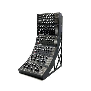 May include: A black modular synthesizer system with numerous knobs, switches, and ports. The system is mounted on a black angled frame. The brand name "Moog" is visible on the front panel. This electronic music instrument is designed for sound synthesis and music production.