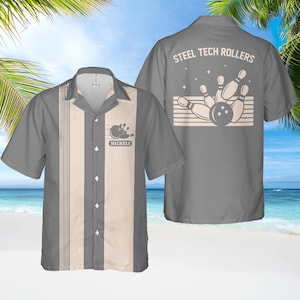 May include: Grey bowling shirt with a cream central panel and vertical stripes. The shirt features a bowling ball and pins graphic with the name "MICHELE" on the front. The back of the shirt has the text "STEEL TECH ROLLERS" and a bowling graphic.