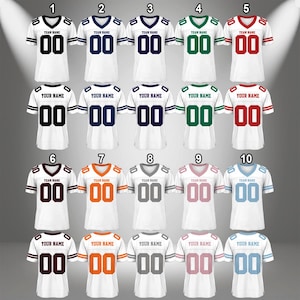 Puede incluir: Diez camisetas de f&uacute;tbol blancas con rayas y n&uacute;meros de diferentes colores. Las camisetas tienen cuello en V y mangas cortas. Los n&uacute;meros son 00. Las rayas son negras, azul marino, verdes, rojas, granate, naranjas, grises, rosas y azul claro.