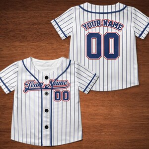 May include: White baseball jersey with blue and red stripes. The jersey has a blue and red number "00" on the front and the text "Team Name" in a blue and red script font. The back of the jersey has the text "YOUR NAME" in blue and red and the number "00" in blue with a red outline.