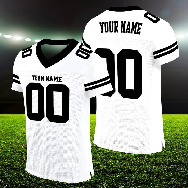 Puede incluir: Camiseta de f&uacute;tbol blanca con rayas y n&uacute;meros negros. La parte delantera de la camiseta dice "TEAM NAME" y tiene el n&uacute;mero "00". La parte trasera de la camiseta dice "YOUR NAME" y tiene el n&uacute;mero "20".