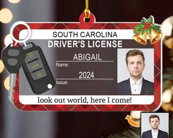 May include: A South Carolina driver's license ornament with a photo, name, and the year 2024. The ornament has a red and black plaid border and includes a car key fob. The text reads "look out world, here I come!"