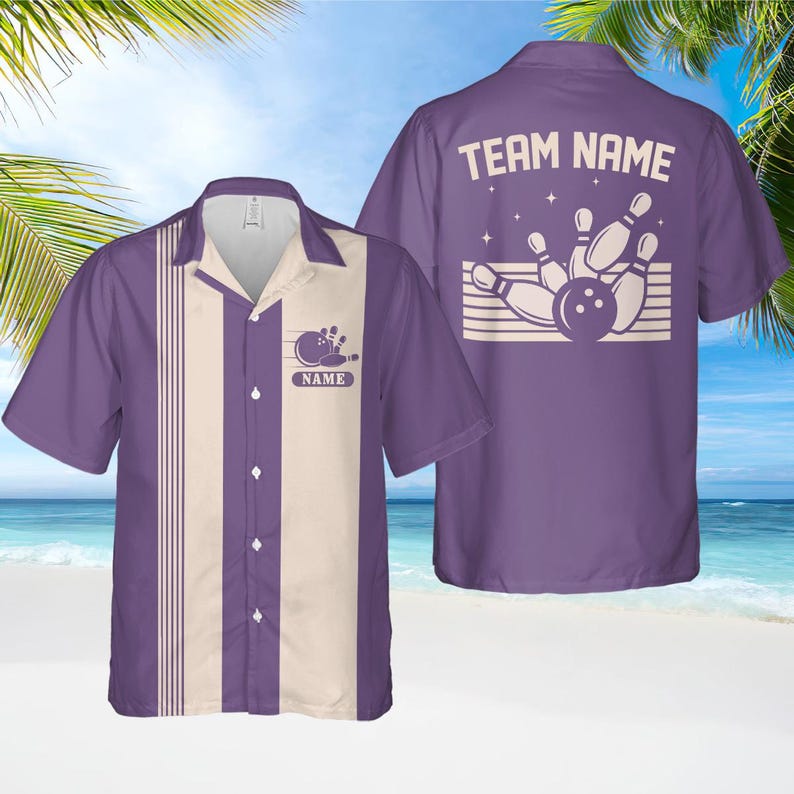 May include: Purple bowling shirt with a cream vertical stripe and bowling pin graphic. The shirt has a button-down front and a collar. The back of the shirt features the text "TEAM NAME" above a bowling pin and ball design.