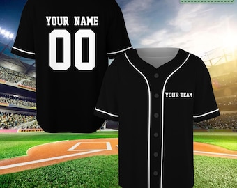 May include: Black baseball jersey with white trim and buttons. The back of the jersey has "YOUR NAME" and "00" printed in white. The front of the jersey has "YOUR TEAM" printed in white.