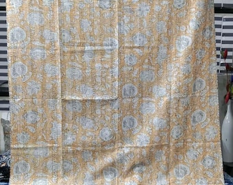 May include: A rectangular quilt featuring a light orange background with a repeating white floral pattern. The fabric is covered in fine, vertical running stitch quilting lines that create a textured appearance across the entire surface.