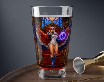 May include: A clear glass tumbler featuring a vibrant, full-colour graphic of a winged figure in a white and blue bodysuit with red accents, standing before a golden throne. The figure holds a glowing purple orb of energy in one hand.