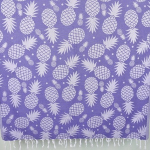 May include: A purple beach towel with a white pineapple pattern.