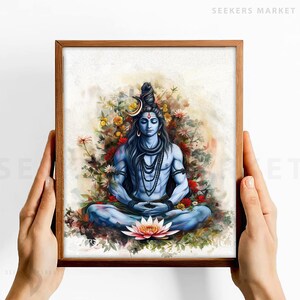 May include: A watercolor painting of a Hindu deity, Shiva, meditating in a lotus position. He is surrounded by flowers and greenery, and has a third eye on his forehead. The painting is framed in a brown wooden frame.