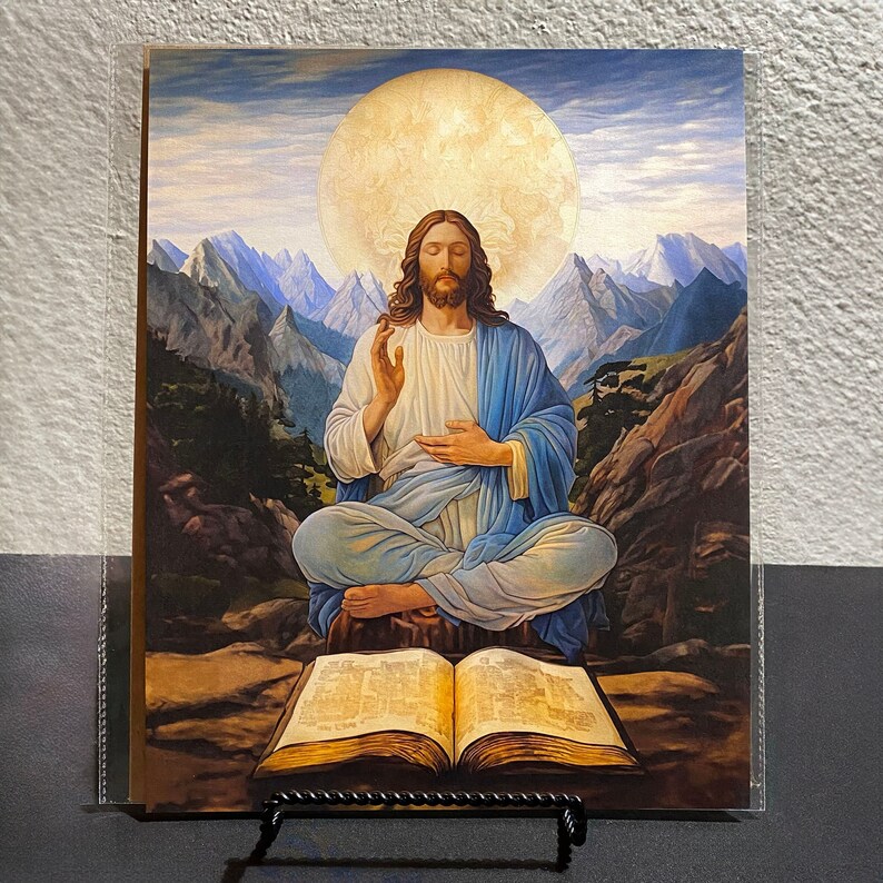 Op de afbeelding: Een schilderij van een man in een blauwe robe die met gekruiste benen zit te mediteren. Hij wordt omringd door bergen en een grote, heldere halo. Een open boek ligt voor hem.