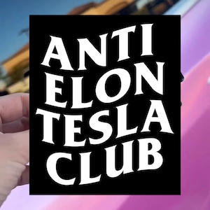 May include: Black and white sticker with the text "ANTI ELON TESLA CLUB" in a bold, stylized font.