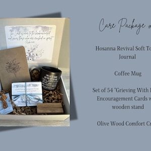 May include: A white gift box filled with a brown journal, a black coffee mug, a set of 54 encouragement cards, a wooden cross, and brown shredded paper. The box has a quote on the lid: "The Lord is near to the brokenhearted and saves those who are crushed in spirit."  Psalm 34:18