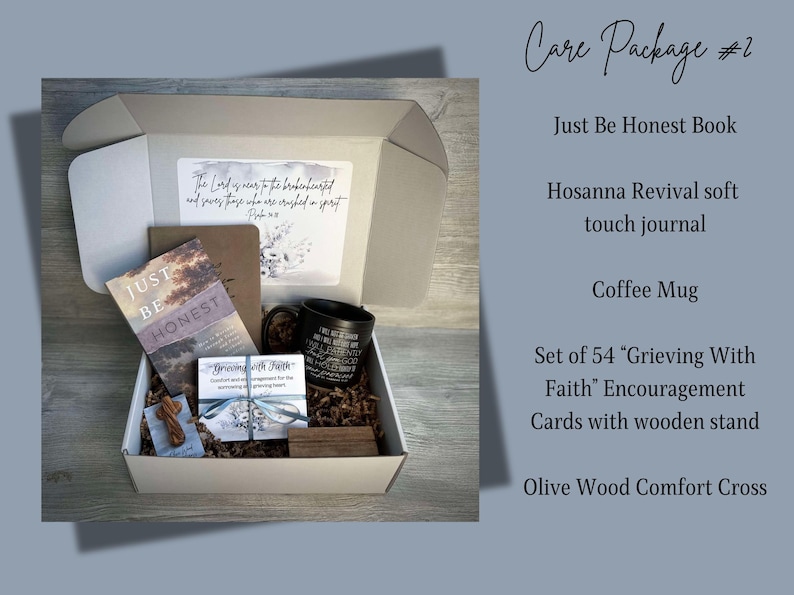 May include: A white gift box filled with a care package. The box contains a book titled "Just Be Honest", a soft touch journal, a coffee mug, a set of 54 encouragement cards with a wooden stand, and an olive wood comfort cross.