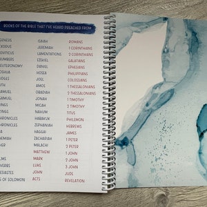 Peut inclure: Un carnet &agrave; spirales avec une liste de livres de la Bible. La couverture est de couleur bleu clair avec un motif aquarelle.