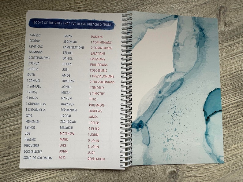 Peut inclure: Un carnet &agrave; spirales avec une liste de livres de la Bible. La couverture est de couleur bleu clair avec un motif aquarelle.
