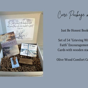 May include: A brown box filled with a care package. The box contains a book titled "Just Be Honest", a set of 54 encouragement cards with a wooden stand, and a small olive wood cross. The box is lined with brown packing paper.