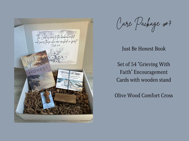 May include: A brown box filled with a care package. The box contains a book titled "Just Be Honest", a set of 54 encouragement cards with a wooden stand, and a small olive wood cross. The box is lined with brown packing paper.
