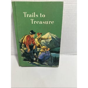 May include: A vintage book titled "Trails to Treasure" with a green cover. The cover illustration depicts three people exploring a mountain landscape. The text is in white, and the overall aesthetic is reminiscent of classic adventure stories.