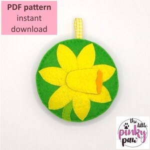 Op de afbeelding: PDF-patroon voor een vilten narcissen ornament. De narcis is geel met een groene stengel en bladeren. Het patroon is direct te downloaden.