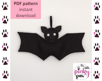 以下が含まれることがあります： 光沢のある黒い目をした黒いフェルトの蝙蝠のPDFパターン。パターンはすぐにダウンロードできます。テキスト「PDF pattern instant download」は、白い背景にピンクで書かれています。