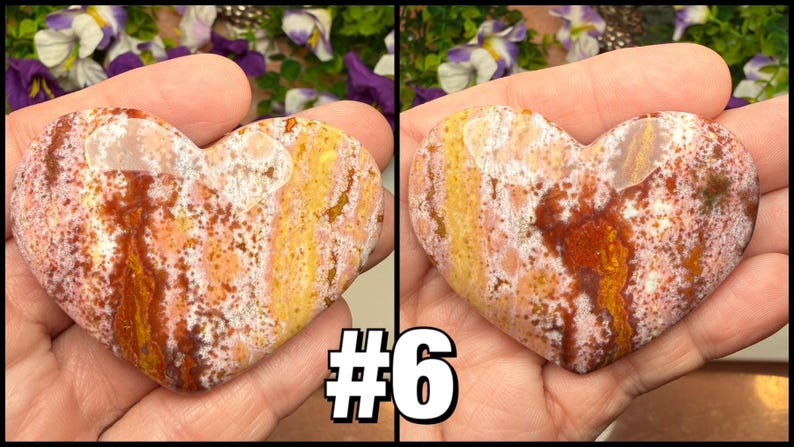 May include: Two heart-shaped stones with a mix of colors, including red, yellow, and white, are held in a hand. The stones have a natural, textured appearance. The number "#6" is displayed in a white and black font at the bottom.