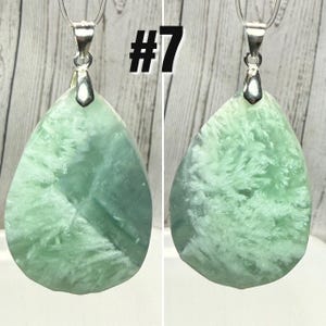 May include: Two teardrop-shaped pendants with a light green and white pattern. Each pendant is attached to a silver-coloured bail and chain. The number "#7" is printed in black on the top of the image.