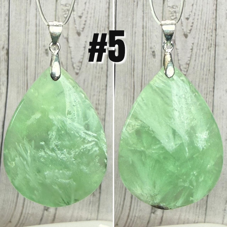May include: Two green fluorite gemstone pendants with silver-coloured bails and chains. The teardrop-shaped stones have white veining. The number "#5" is printed in black on the image.