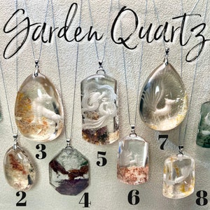 May include: Nine different garden quartz pendants with various designs and colors. The pendants are numbered 1 through 9. The pendants are all on silver chains.