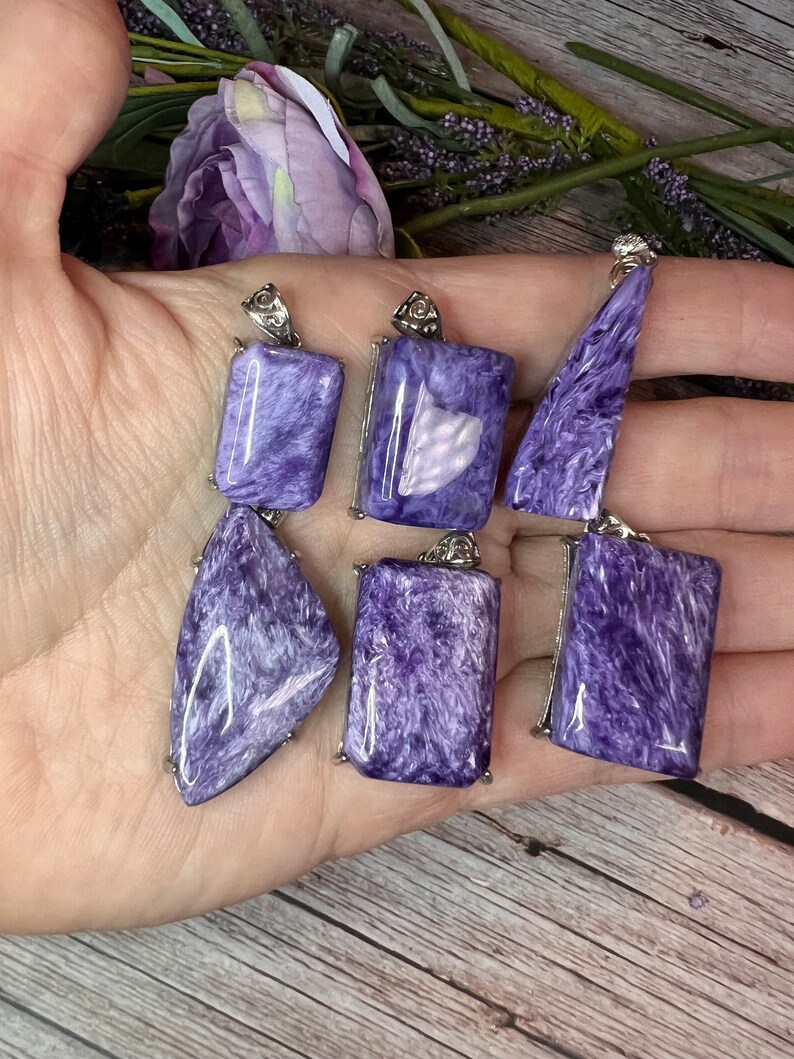 May include: Six purple and silver pendants with a variety of shapes and sizes. The pendants are made of a shimmering, iridescent material.