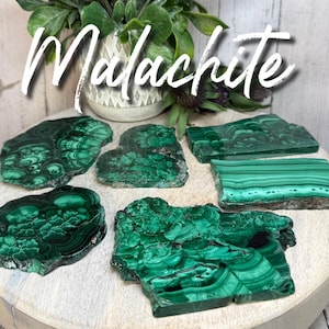 May include: Malachite slabs in various shapes and sizes, showcasing a vibrant green color with intricate patterns. The slabs are displayed on a light-colored wooden surface, with the word "Malachite" in white script.