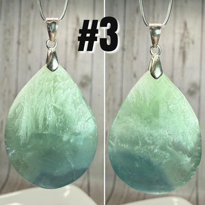 May include: A green and blue teardrop pendant with a silver chain. The pendant has a textured surface and a silver bail. The number "#3" is in black, at the top of the image.