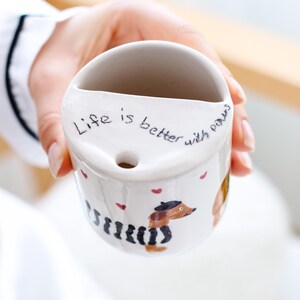 May include: White ceramic mug with a dachshund illustration and the text "Life is better with paws".