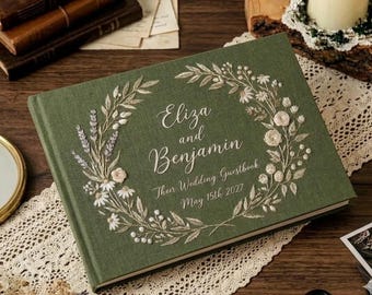 Könnte beinhalten: Ein grünes Hochzeitsgästebuch mit gesticktem Blumenkranz-Design. Auf dem Einband stehen die Namen "Eliza and Benjamin" und "Their Wedding Guestbook May 15th 2027". Ein dekorativer Artikel für Hochzeiten.