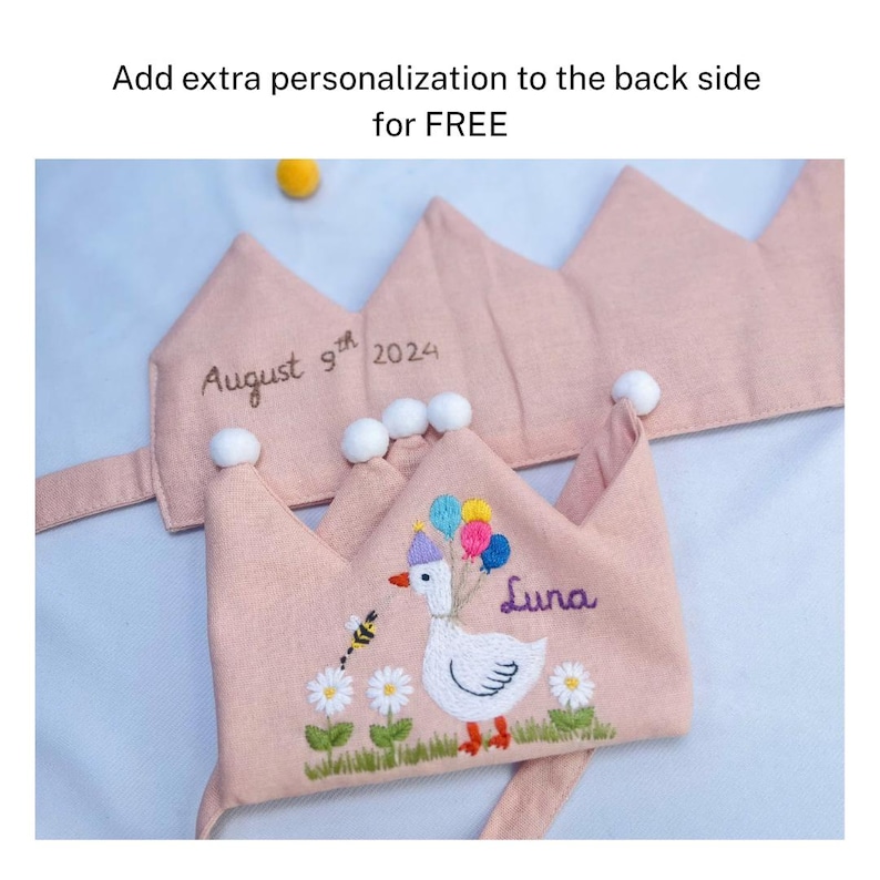 May include: Pink fabric crown with embroidered details. The crown features a white goose holding balloons, the name "Luna", and the date "August 9th 2024". Additional text reads "Add extra personalization to the back side for FREE".